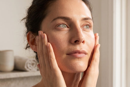 woman holding her face after applying some bakuchiol serum that's pregnancy safe