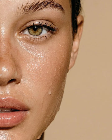 Close-up of woman's dewy skin with water droplets on face